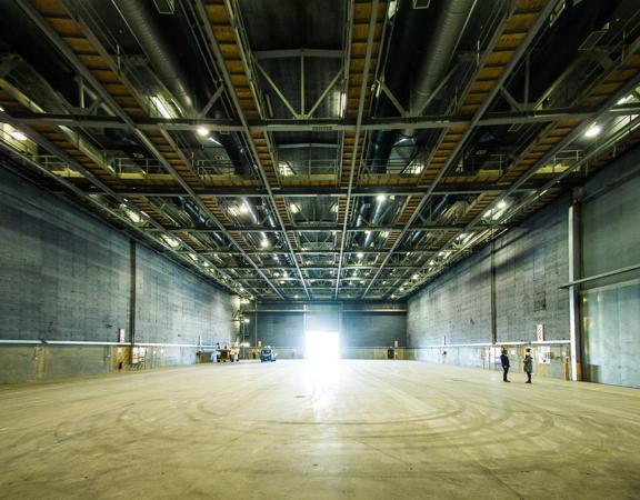 Inside the K Stage at Stone Street Studios. It is a large space with a concrete floor and a grid of catwalks on the ceiling.