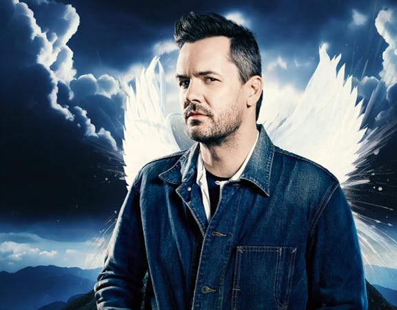 Jim Jefferies with angel wings on a stormy mountain background.