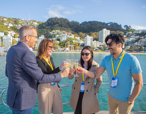 Delegates share a drink on a boat in the middle of Wellington harbour.