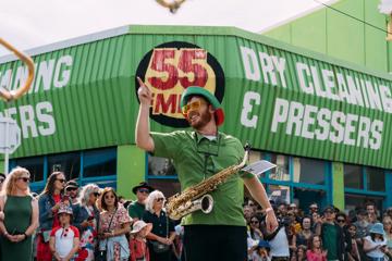 A saxophone player in green performs for festival attendees at CubaDupa.