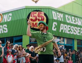 A saxophone player in green performs for festival attendees at CubaDupa.