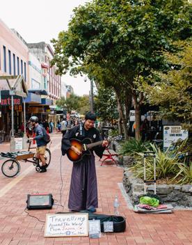 A street performer playing the guitar on Cuba Street in Te Aro, Wellington.