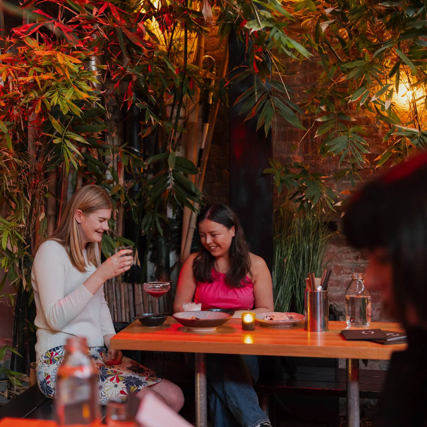 Two friends enjoy food and drinks at Dragonfly.