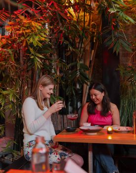 Two friends enjoy food and drinks at Dragonfly.