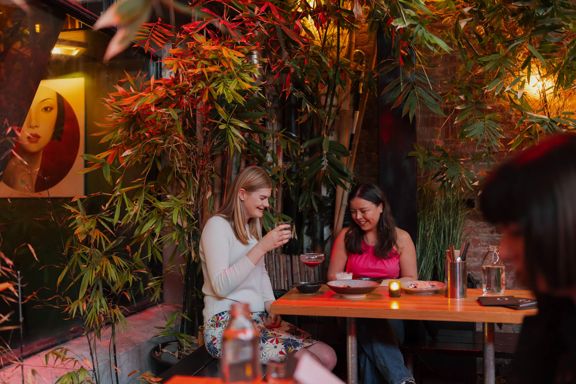 Two friends enjoy food and drinks at Dragonfly.