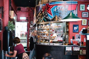 The interior of Fidel's Cafe, with customers ordering cabinet food.