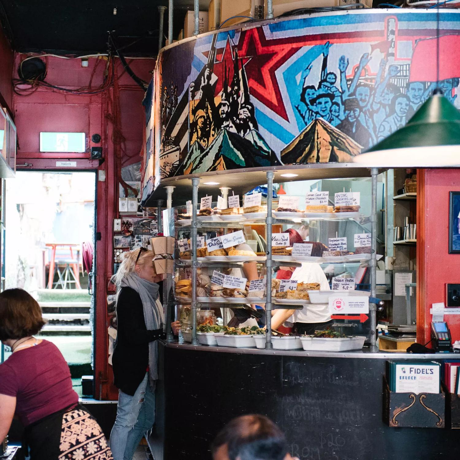 The interior of Fidel's Cafe, with customers ordering cabinet food.