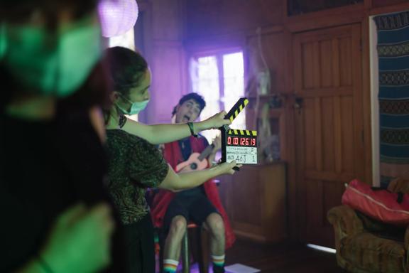 On the set of Little Apocolypse, where a set working is holding a clapper board in front of an actor pulling a funny face.