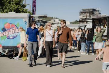 3 people walking through the Harbourside Markets.