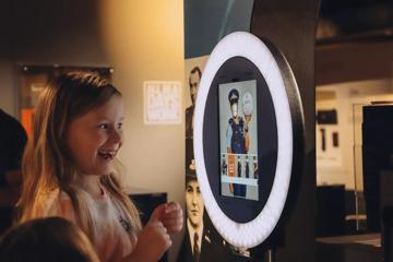 A young child playing with an interactive photo booth in the New Zealand Police Museum.