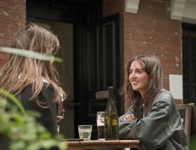 Two friends enjoy drinks on the patio at Woodward Street Distilling Company in Wellington.