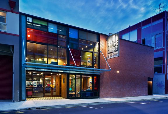 Exterior of Light House Cinema Cuba on Wigan Street in Wellington, featuring a modern glass-fronted entrance illuminated at dusk.