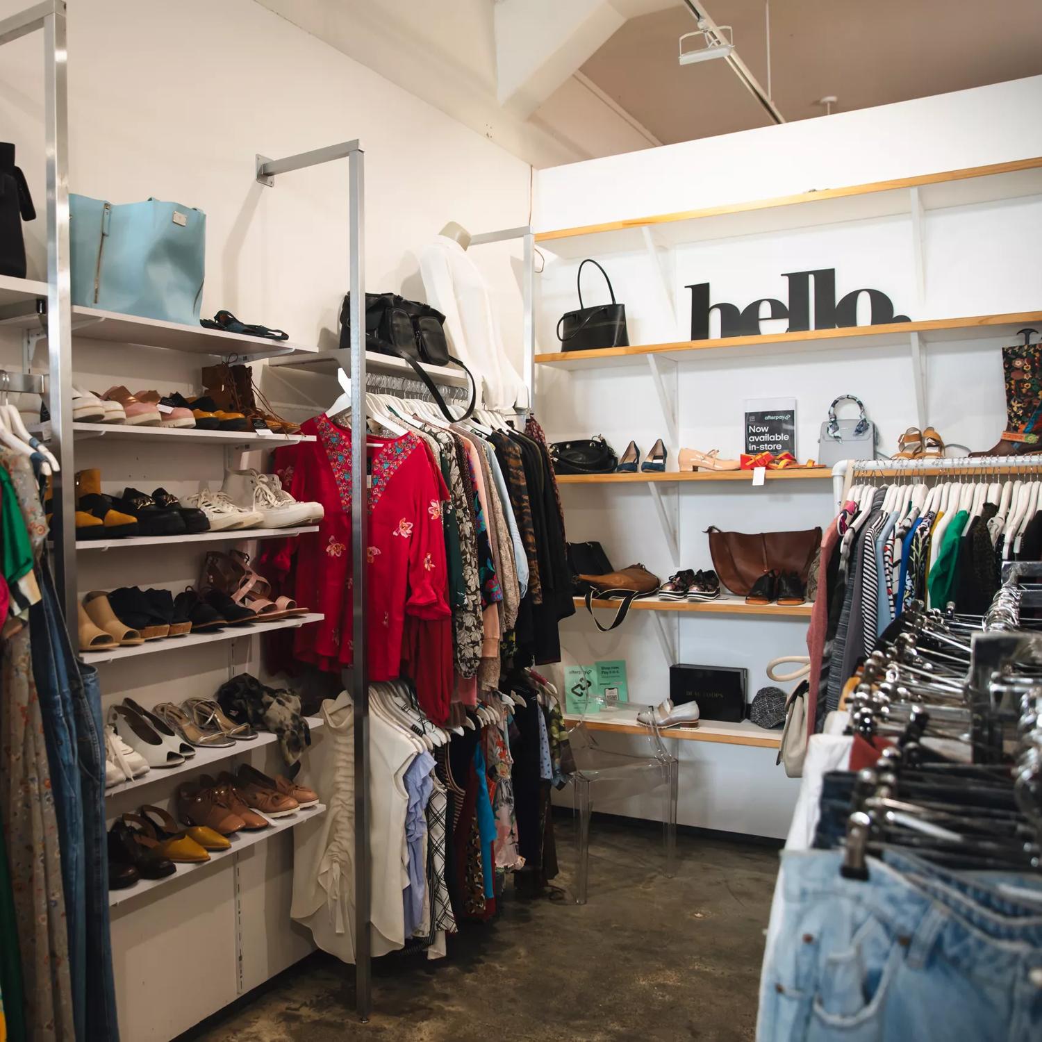 The interior of Honour, a secondhand clothing store located on Vivian Street in Te Aro, Wellington. The space has concrete floors, clothing racks, and shelves with purses and shoes on display.