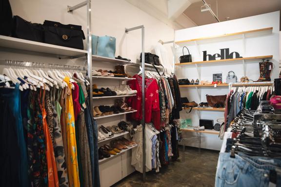 The interior of Honour, a secondhand clothing store located on Vivian Street in Te Aro, Wellington. The space has concrete floors, clothing racks, and shelves with purses and shoes on display.