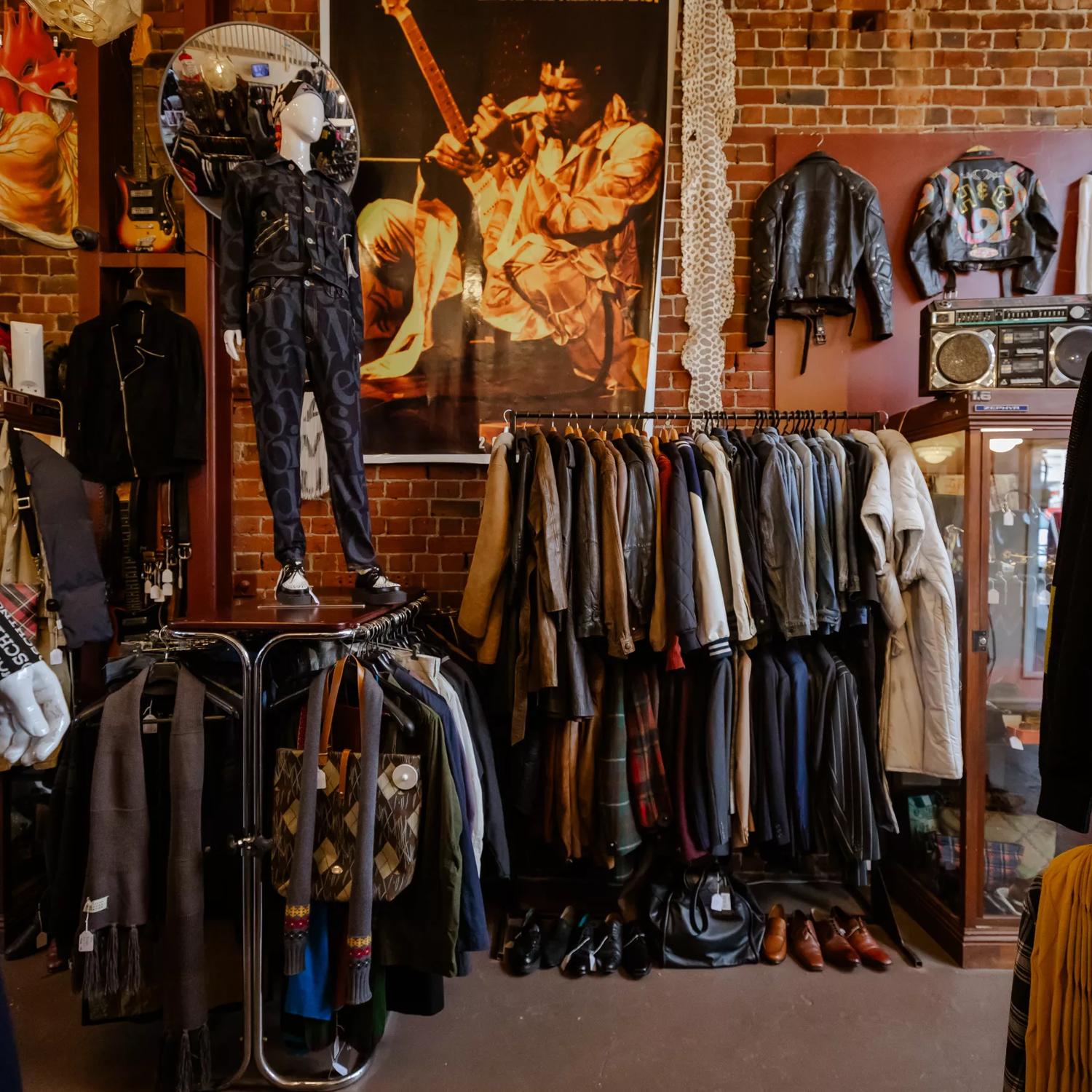 The moody interior of Hunters & Collectors, with racks of vintage clothes around the room and brick walls surrounding.