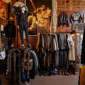 The moody interior of Hunters & Collectors, with racks of vintage clothes around the room and brick walls surrounding.