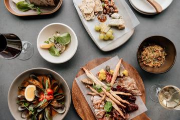 Plates of food inside The Runholder, including mussels, fish, and charcuterie boards.