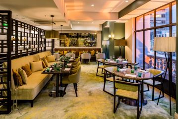 The restaurant inside DoubleTree by Hilton Wellington has chartreuse-coloured velvet couches and chairs around café tables.