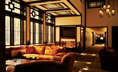 A living room dining area flooded with amber sunlight from the window.