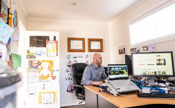TEG Risk Technology founder Hamish Baker in his at-home office, where the walls are decorated with his children's artworks.