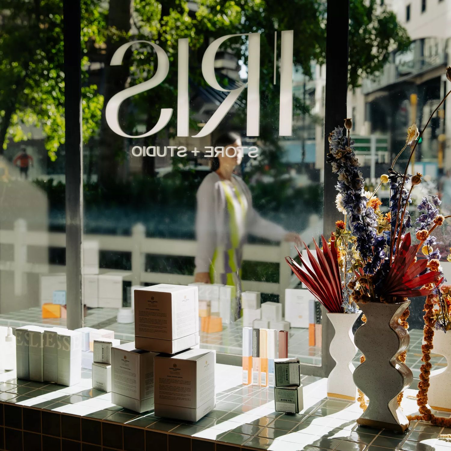 Inside Iris Store + Studio looking out to the street, with dried flowers in a vase and their products by the window.