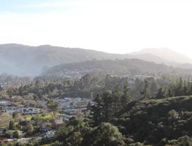 Mangaroa Valley Road screen location, a scenic rural setting with native forest, farmland, and a mountainous backdrop.