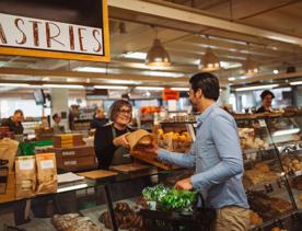 A person buys bread at the bakery section of Moore Wilson's.