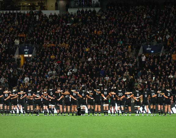 The All Blacks New Zealand rugby team stand, arm in arm, during the All Blacks v Australia Lipovitan-D Rugby Championship match, Sky Stadium, Wellington, New Zealand, Saturday, 28 September 2024.