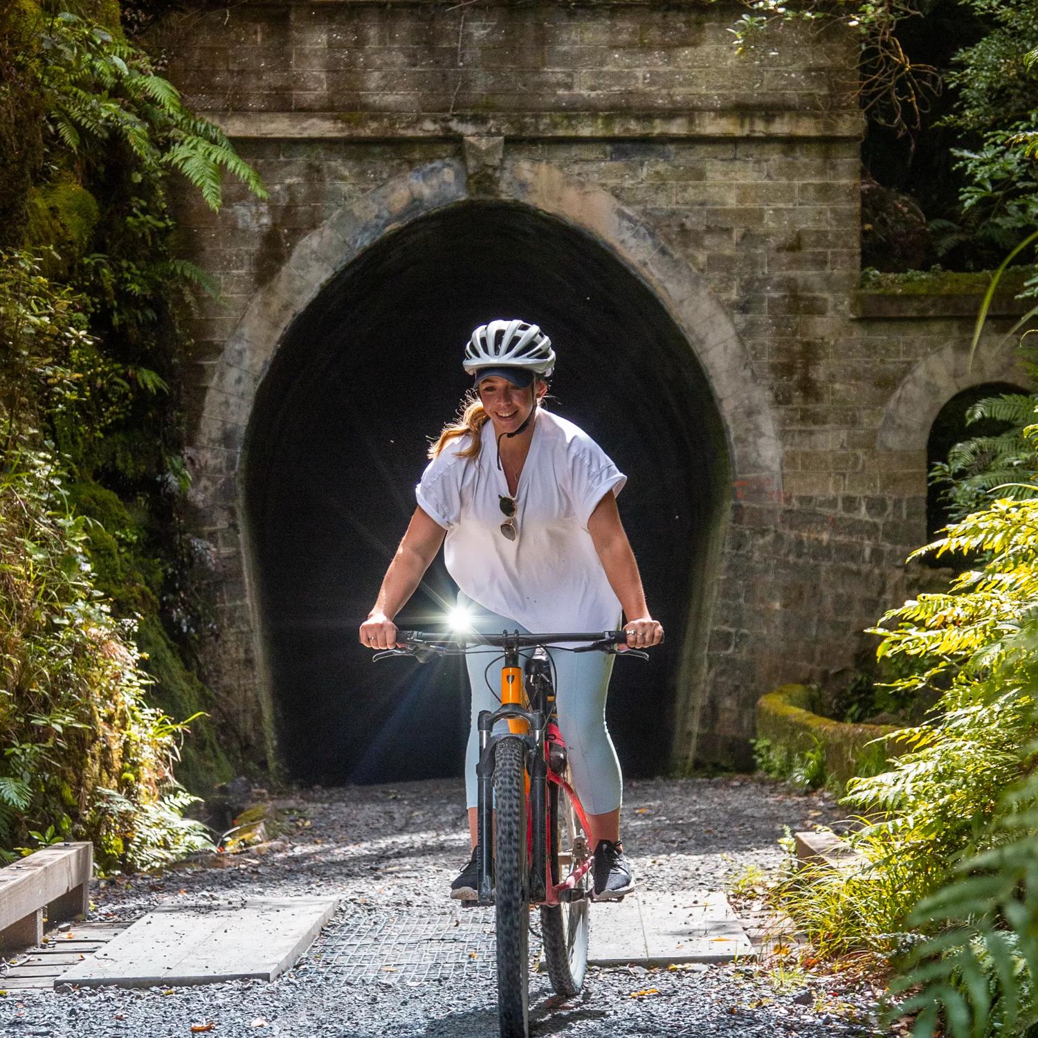 A person on a bike exits a tunnel on the Remutaka Cycle Trail.