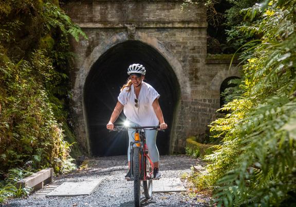 A person on a bike exits a tunnel on the Remutaka Cycle Trail.