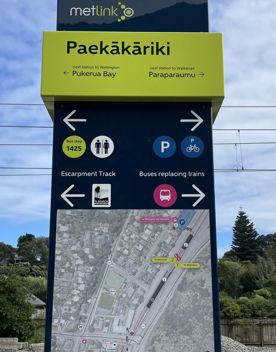 Metlink Paekakariki Train Station sign showing directional arrows for the Escarpment Track.