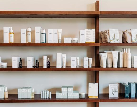 Shelves inside Iris Store + Studio adorned with their beauty products in white bottles.