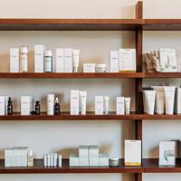 Shelves inside Iris Store + Studio adorned with their beauty products in white bottles.