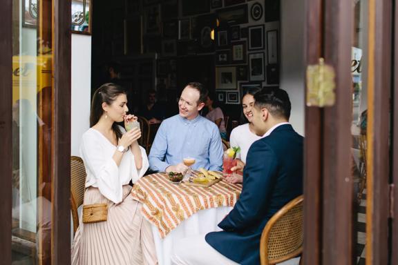 Four people enjoying cocktails and appetizers at Crumpet, a cosy café and bar nestled in the Opera House, on Manners Street in Te Aro, Wellington.