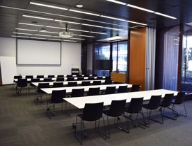 Five long tables sit in the Programme Room in a classroom layout at the Tiakiwai Conference Centre.