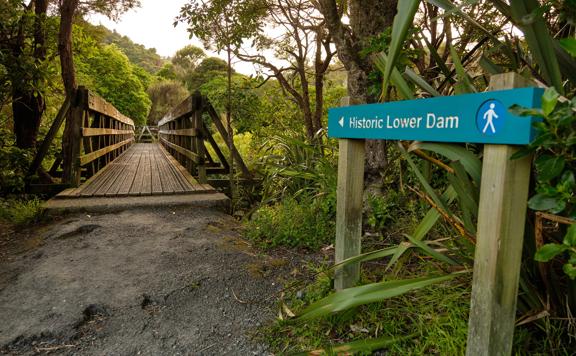 The sign for Historic Lower Dam pointing towards a bridge on the Gums loop.