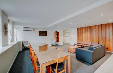 A Park Hotel suite has been set up for a boardroom meeting. It has two couches and a long table with 12 seats.