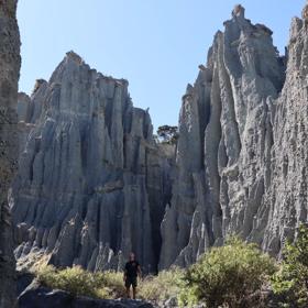 A person walking along a rocky canyon at the Putangirua Pinnacles track in the Wairarapa.