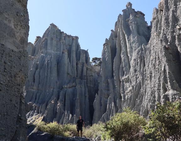 A person walking along a rocky canyon at the Putangirua Pinnacles track in the Wairarapa.