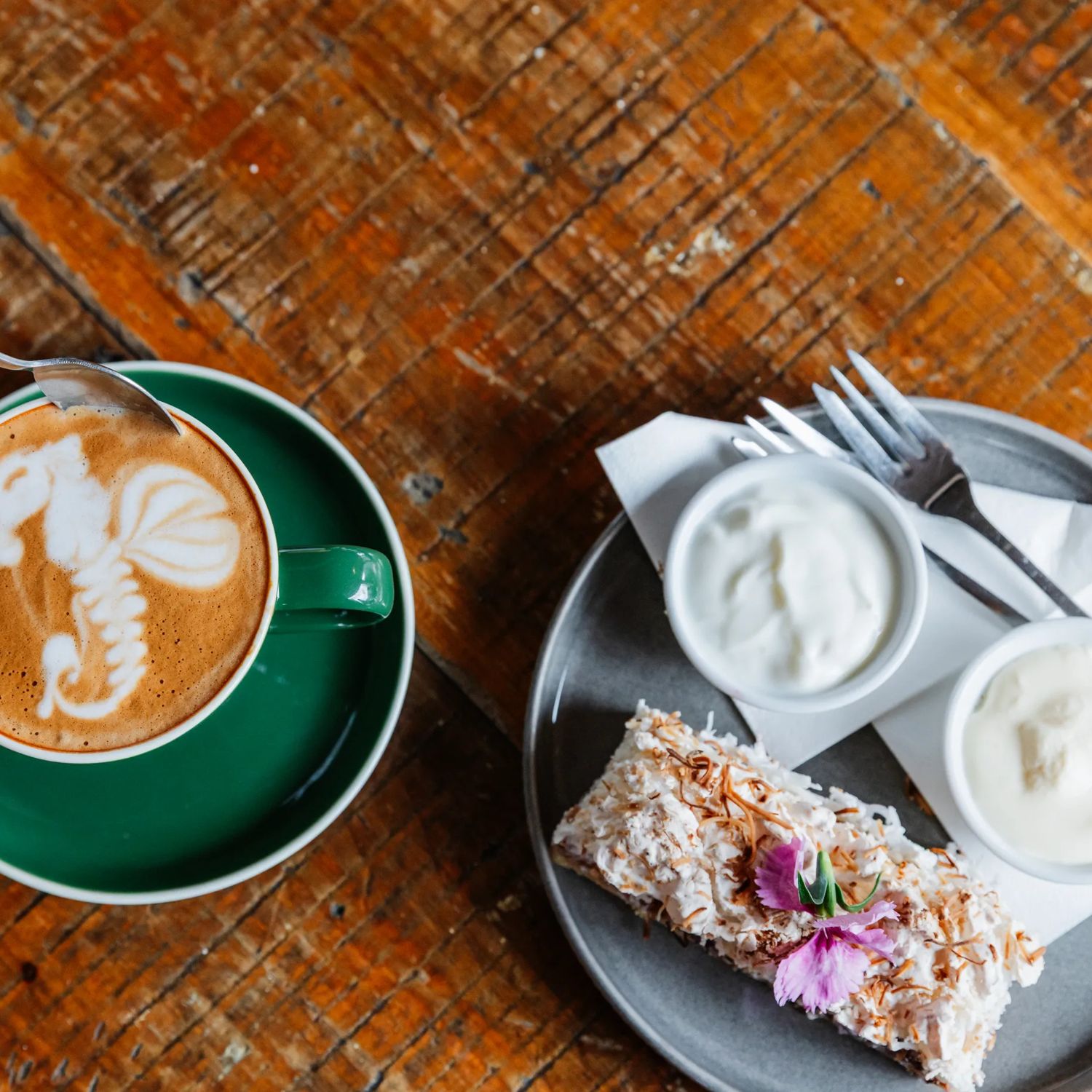 Latte art and a dessert on a table.