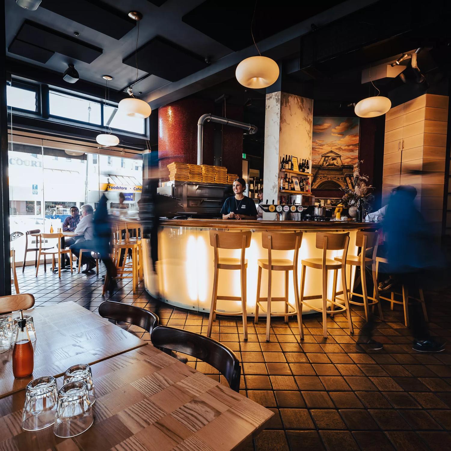 Inside Scopa, an Italian pizzeria on Cuba Street in Te Aro, Wellington. The dimly lit space has copper tiles and modern decor. 