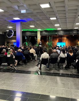 People are seated at an event in the Te Ahumairangi Foyer at the Tikiwai Conference Centre.