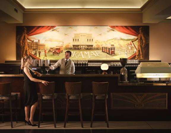 The bar at Roxy Cinema in Miramar, Wellington. A patron in a black dress is waiting while a bartender pours a drink.