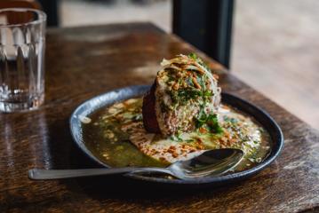 Close up shot of Aloo Tikki dish with spoon.