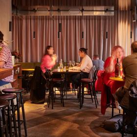 Different tables with people dining and drinking wine at Astoria in Wellington.