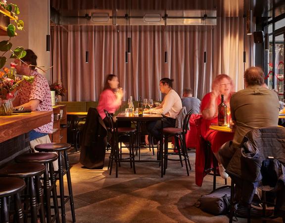 Different tables with people dining and drinking wine at Astoria in Wellington.