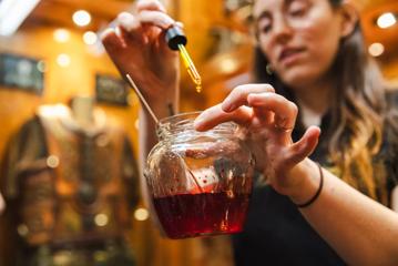 A person makes a fake blood concoction in a glass jar.