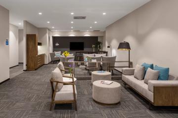 The foyer inside Oaks Wellington Hotel, with grey and dark wood decor.