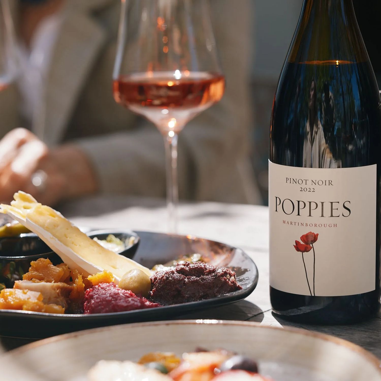 Elegant tasting platter next to a bottle of Rose at Poppies