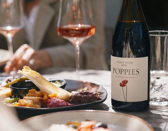 Elegant tasting platter next to a bottle of Rose at Poppies